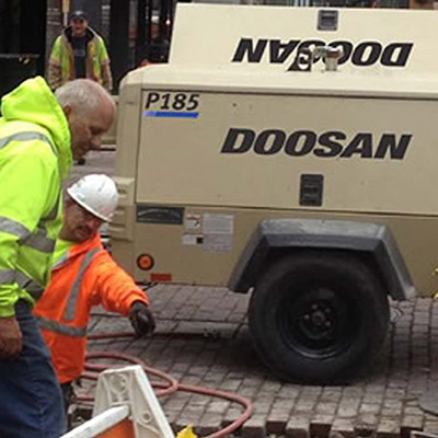 Picture showing a Doosan Compressor being used in high street maintenance